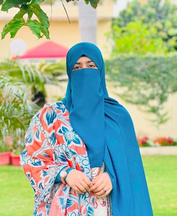 in this a girl is standing in the park- umama faiz